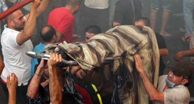 Lebanese emergency personnel evacuate the body of a man from the site of a car bomb between the Bir el-Abed and Roueiss neighborhoods, in the southern suburb of Beirut on Aug. 15.