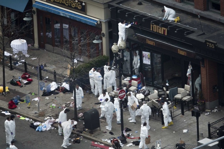 Officials take crime scene photos a day after two explosions hit the Boston Marathon in Boston, Massachusetts April 16, 2013.