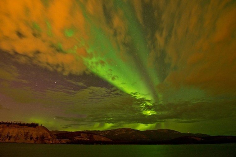 The aurora's green glow blends with the orange glow of light reflected off clouds to produce a colorful scene for late summer near Whitehorse in Canada's Yukon Territories. Feast your eyes on more pictures from photographer Jonathan Tucker's website.