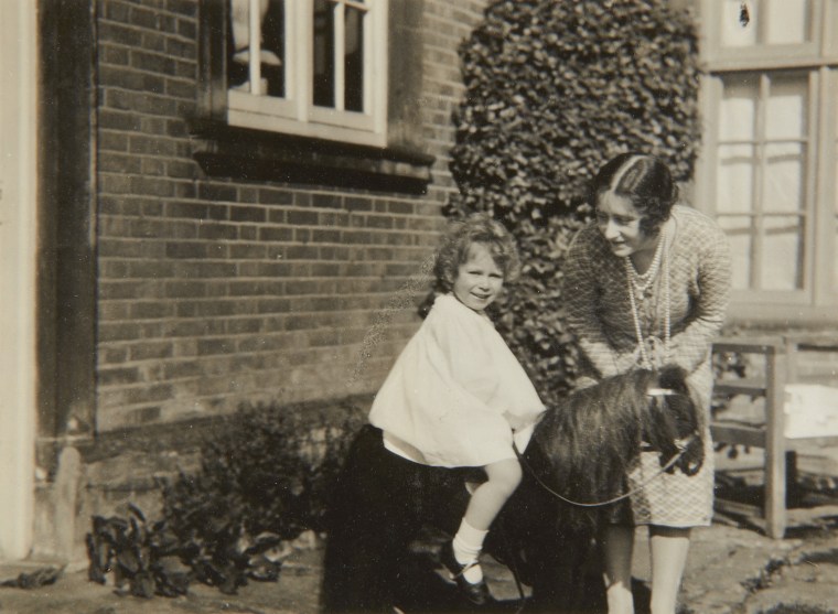 Princess Elizabeth with a toy house in front of Naseby Hall in 1928. The photo was taken by her father, King George VI when he was the Duke of York.