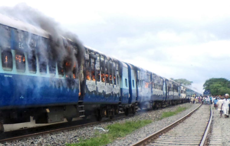 Train coaches of the Rajya Rani Express, set on fire by an angry mob, Monday.