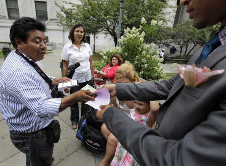 Braulio Cuenca is paid by groom Jorge Mejia after the wedding ceremony.