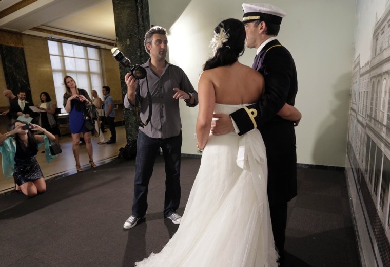 Goran Veljic poses groom Lt. Lisardo Hernandez and bride Alnair Vivanco, of Oviedo, Spain, before their ceremony inside City Hall on Aug. 7.