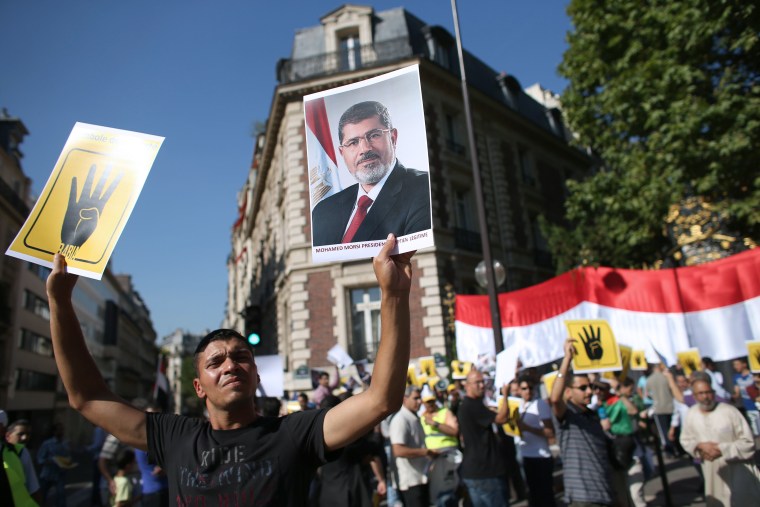 A protester holds a poster of Egypt's ousted President Mohammed Morsi during a protest in front of Saudi Arabia's embassy in Paris on Tuesday.