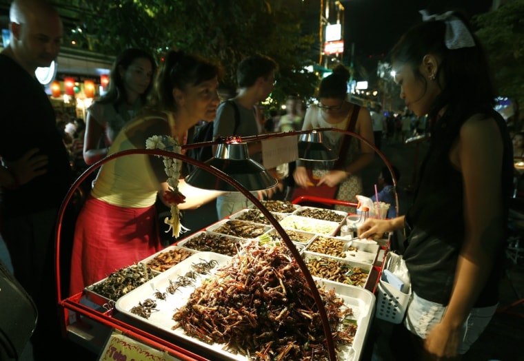 Foreign tourists buy fried insects from a Thai vendor at Khao Sarn road, a tourist area in Bangkok, Thailand, on July 20.