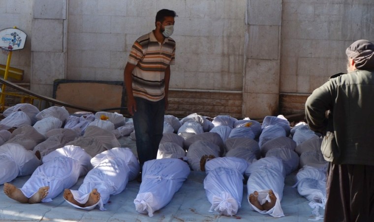 Syrian activists inspect the bodies of people they say were killed by nerve gas in the Ghouta region near Damascus on Wednesday.
