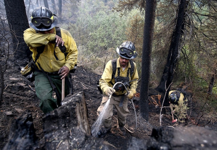 Firefighters with the private contract company Great Basin Fire mop up part of the 104,457-acre Beaver Creek Fire on Monday in the Baker Creek area north of Ketchum, Idaho.