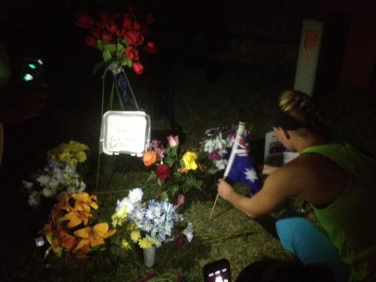 Sarah Harper, Chris Lane's girlfriend, lays flowers at a roadside memorial service.