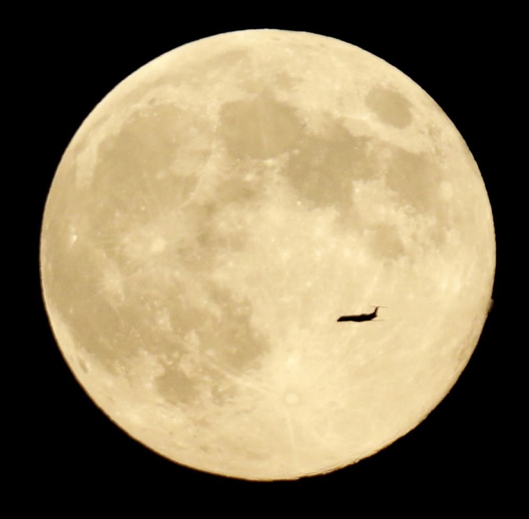 A plane cruises in front of the full moon on Aug. 20, as seen from a vantage point in West Orange, N.J. This was the third full moon out of four during the summer season. By some definitions, that's a blue moon. Such a phenomenon happens only rarely, which explains why