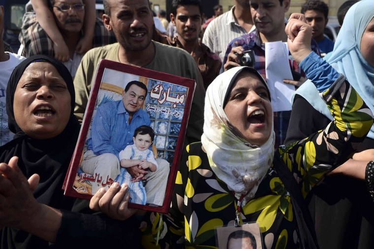 A supporter of former Egyptian President Hosni Mubarak raises up his portrait to show her support for the ousted autocrat outside the Tora prison in Cairo shortly before he was released.