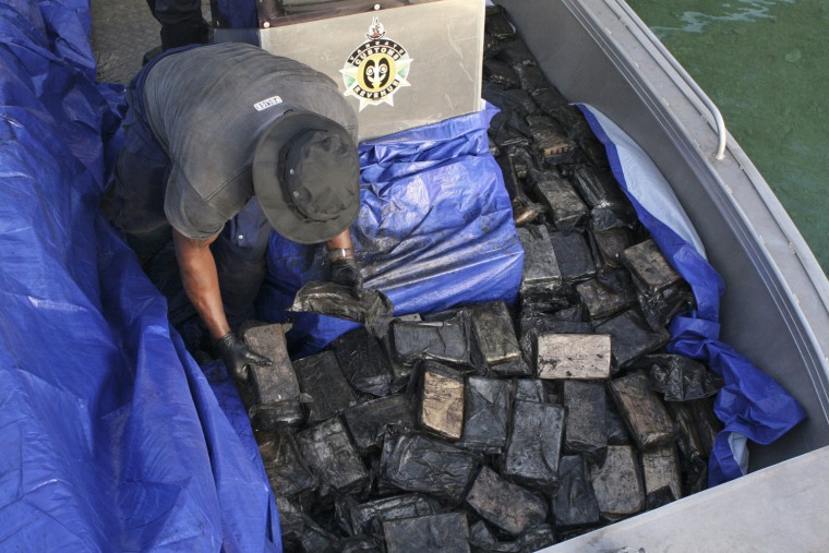 An officer gathers packages of cocaine found on the yacht.