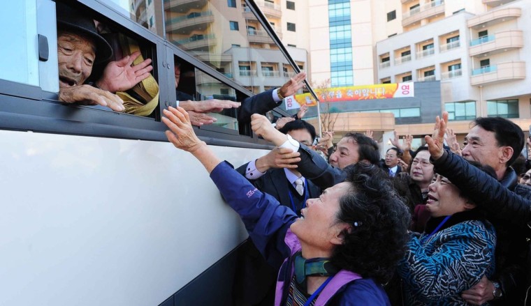North Koreans (on bus) wave to their South Korean relatives as they bid farewell following a three-day family reunion meeting at the Mount Kumgang resort on the North's southeastern coast, near the border, on November 1, 2010.