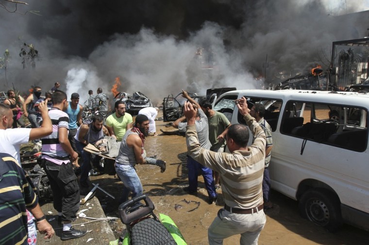 People carry a dead body away from the destruction after explosions hit two mosques in Tripoli.