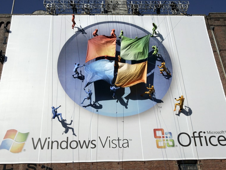 A group of performers from the Grounded Aerial Dance Theater unfurl the Microsoft logo as they hang from a seven-story tall building during the Micros...