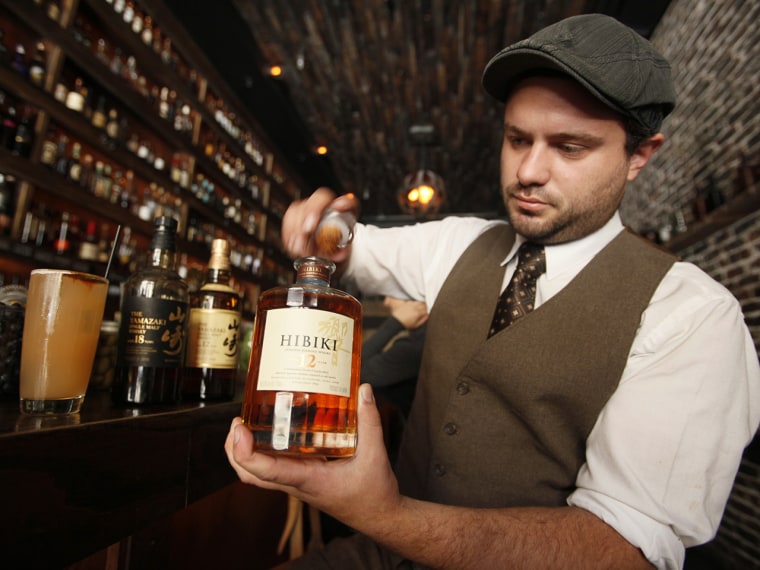 General manager Owen Westman opens a bottle of 12-year-old Hibiki Japanese whisky at the Rickhouse bar in San Francisco, Friday, Aug. 6, 2010. At left...