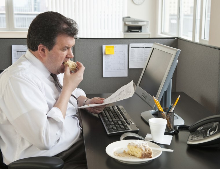 Business man eating at desk Getty Images stock overweight fat
