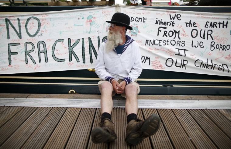 Protester Michael McIntyre sits beside his boat with an anti-fracking banner in Enniskillen, Northern Ireland, on June 15.