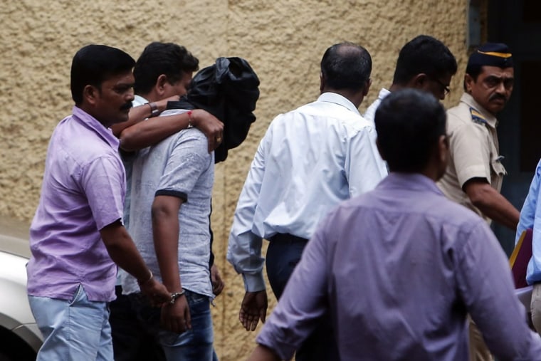 Police officers escort a man who is accused of raping a photo journalist at a court in Mumbai August 24, 2013.