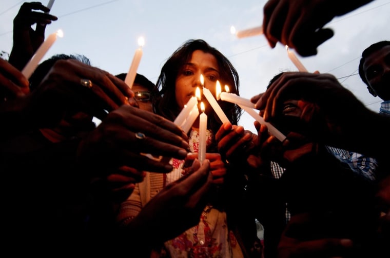 Indian journalists, photojournalists and media personnel light candles during a vigil in Bangalore on 24 August 2013.