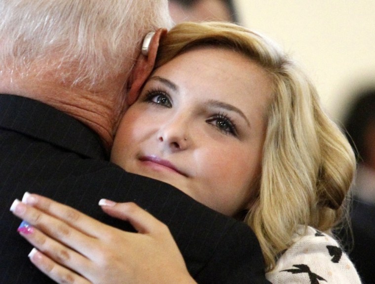 Kidnap victim Hannah Anderson hugs an attendee during a memorial service for her mother Christina Anderson, 44, and her 8-year-old brother Ethan at the Guardian Angels Catholic Church in Santee, California August 24, 2013.