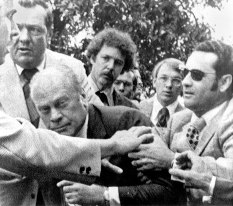 President Gerald Ford is shielded by the Secret Service after an assassination attempt by Lynette