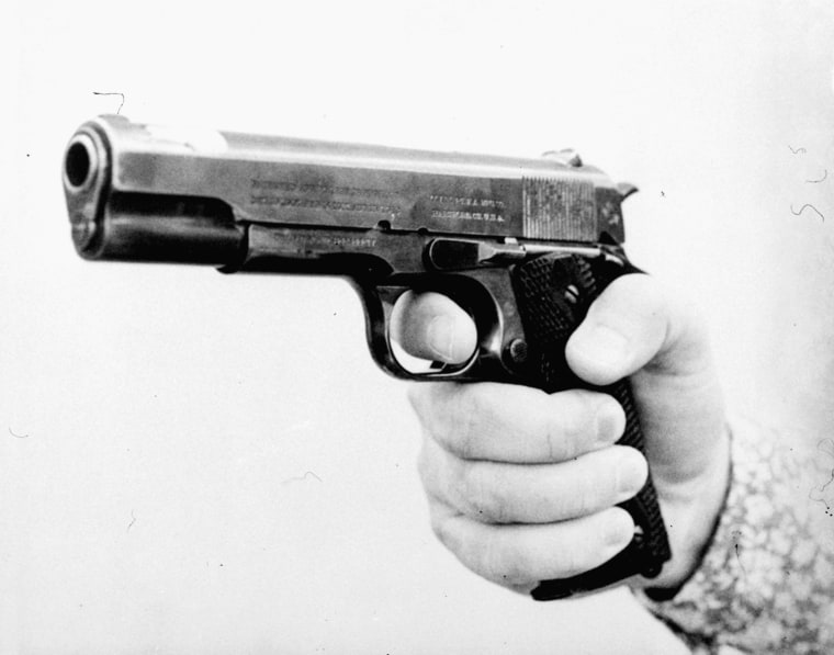 A Sacramento police official holds the 0.45-caliber gun that Lynette Fromme pointed at President Ford.