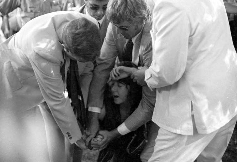 Secret Service agents put handcuffs on Lynette Fromme. The agent holding Fromme at center, wearing dark glasses, is Larry Bruendorf.