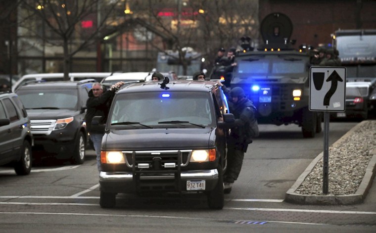 Law enforcement vehicles drive to the scene near where Boston Marathon bombing suspect Dzhokhar Tsarnaev was thought to be hiding in Watertown, Mass., on April 19, 2013. Tsarnaev was captured later that night, bleeding and hiding in a boat in a nearby backyard.