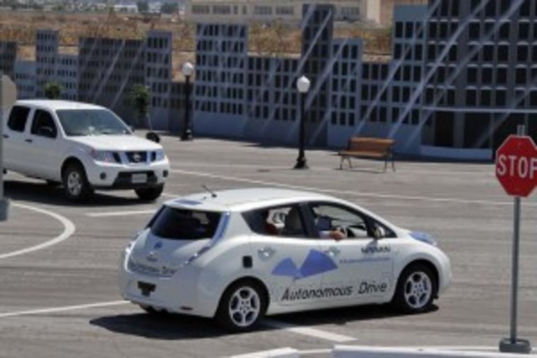 A prototype Nissan Leaf autonomous vehicle negotiates a simulated urban intersection, complete with cross traffic.