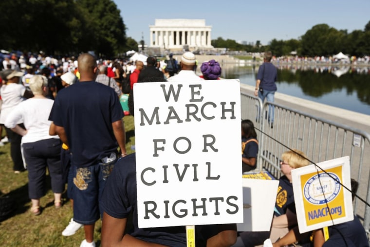 Marchers hold signs during the 50th anniversary of the 1963 March on Washington for Jobs and Freedom at the Lincoln Memorial in Washington.