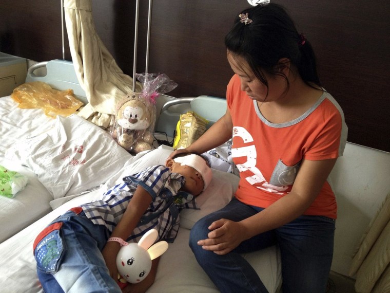 Guo Bin recuperates near his mother from the attack, which left him blind.