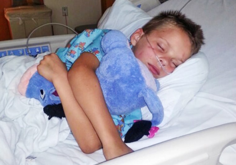 In this photo provided Monday, July 22, 2013, by the Woessner family, Nathan Woessner, with cuts and scrapes on his face from his ordeal, sleeps at a Chicago Hospital. Relatives said over the weekend that the six-year-old Illinois boy who was rescued after spending hours buried beneath an Indiana sand dune is eating regular food and visiting the playroom at the hospital. (AP Photo/Courtesy Woessner Family)