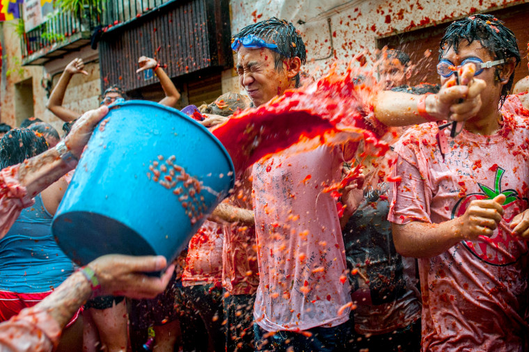 Revellers covered by tomato pulp participate the annual Tomatina festival on Aug. 28, 2013 in Bunol, Spain.