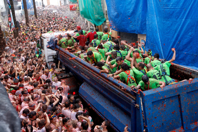 Crowds of people throw tomatoes at each other during the annual