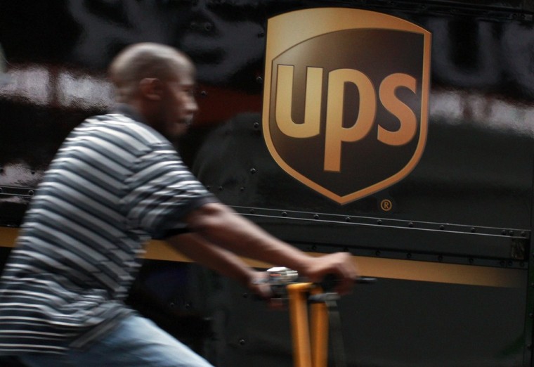 A bicycle delivery man rides past a United Parcel Service (UPS) truck in New York's Times Square in this July 23, 2012 file photo. United Parcel Servi...