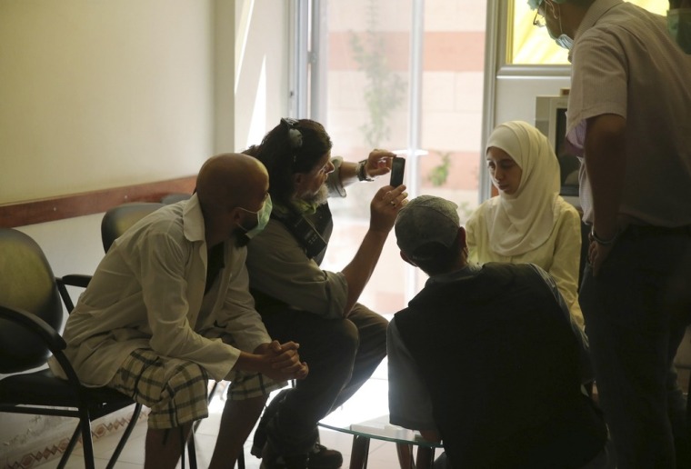 A U.N. chemical weapons expert takes a picture of a woman affected by an apparent gas attack, at a hospital where she is being treated in the Damascus suburb of Zamalka on Aug. 29.