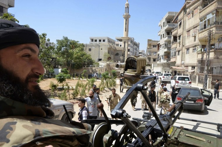 Free Syrian Army fighters escort a convoy of U.N. vehicles during their visit to one of the sites of an alleged chemical weapons attack in Zamalka on Aug. 28.