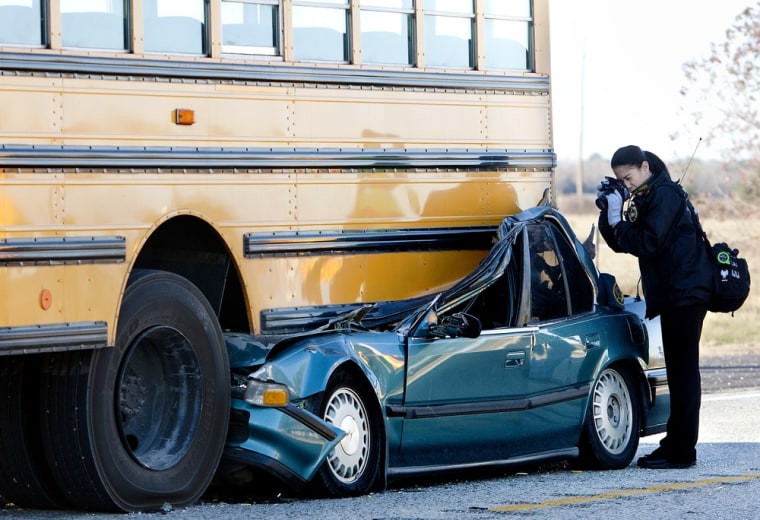 An investigator photographs the aftermath of a fatal bus accident Wednesday, Dec. 12, 2012, in Hockley, Texas. Authorities said the driver of the car ...