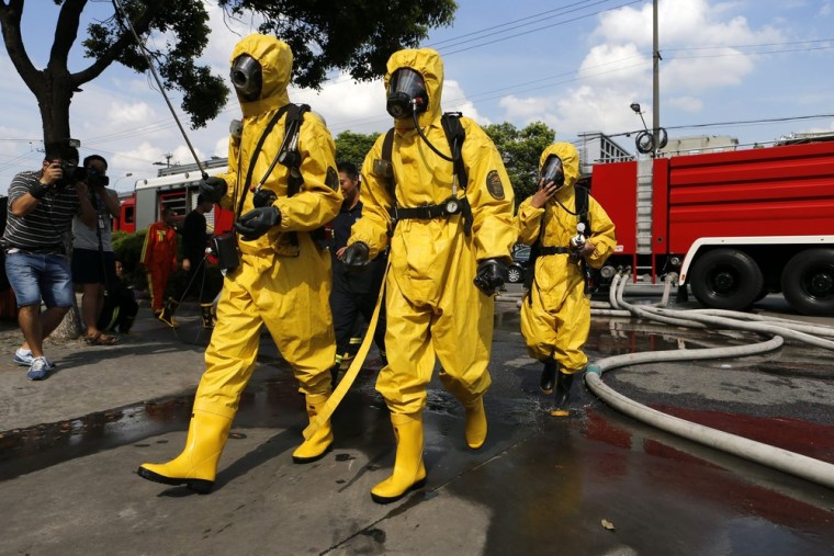 Firemen in protective clothing and masks work at the site of a liquid ammonia leak at a cold storage facility in Baoshan district of Shanghai, Saturday.
