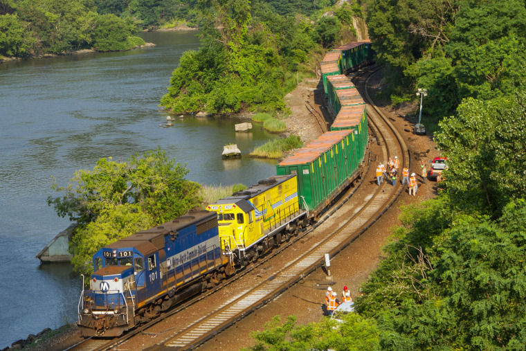 Metro-North employees work to get a freight train back on the tracks between the Marble Hill and Spuyten Duyvil stations in New York Friday morning, July 19, 2013, after the train hauling garbage derailed the previous night.