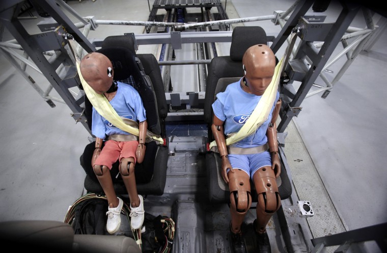 Two Ford Motor Co. crash test dummies sit strapped in a Servo Sled Crash Simulator with seat belt air bags in Dearborn, Michigan November 5, 2009. For...