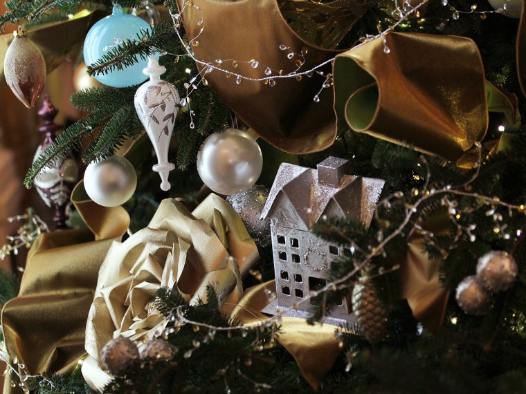 WASHINGTON, DC - DECEMBER 04:  Ornaments and decorations are hung on a Christmas tree in the East Room of the White House December 4, 2013 in Washingt...