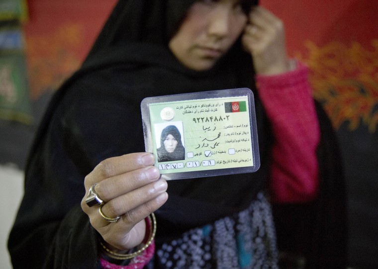 An Afghan woman shows a voter registration card she got at a mosque being used as a mobile registration office in Kabul, Afghanistan, on Nov. 9.
