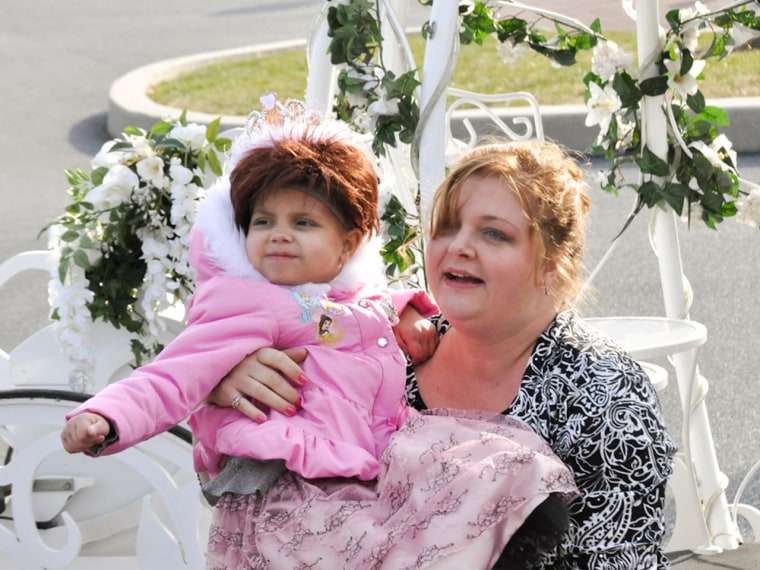 Image: Brielle’s mother, Tina Kelly, carries her daughter from the horse-drawn carriage to the party.