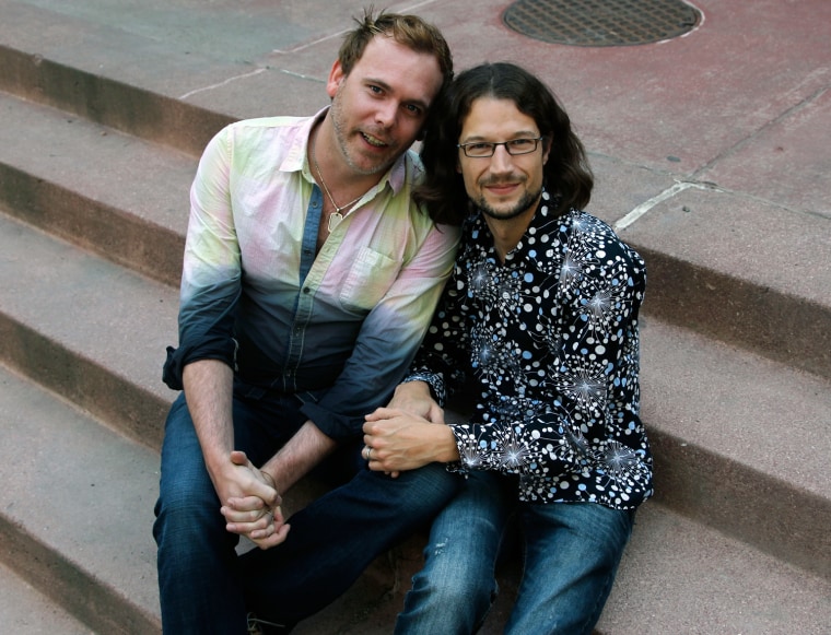 Dave Mullins, right, sits for a portrait with his husband Charlie Craig, in Denver.