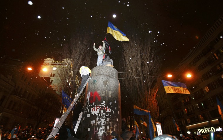People climb up to the top of a pedestal after a statue of Soviet state founder Vladimir Lenin was toppled by protesters during a rally organized by supporters of EU integration in Kiev, on Dec. 8, 2013.