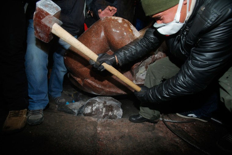An anti-government protester beats the head of the statue of Vladimir Lenin with a sledgehammer in Kiev, Ukraine, on Dec. 8, 2013.