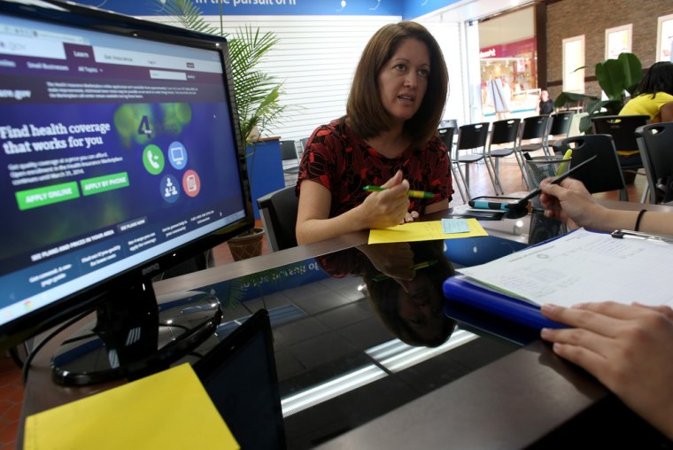 Venita Mendez works with an insurance agent as she looks to purchase an insurance policy under the Affordable Care Act on Nov. 14, in Hialeah, Fla.