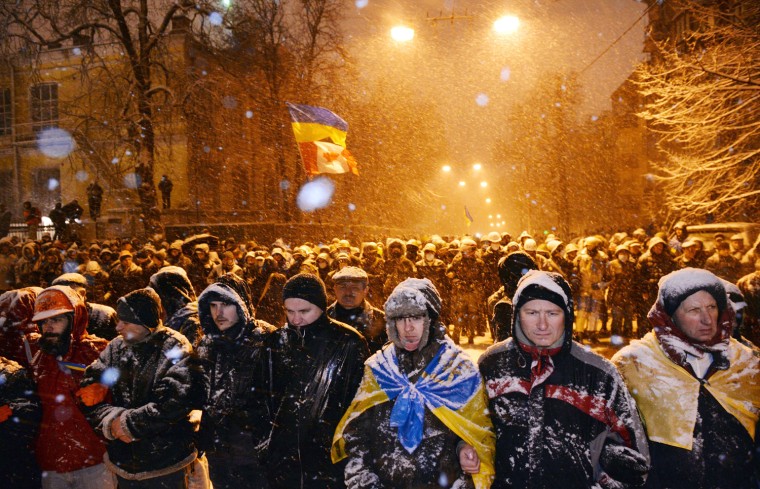 Pro-EU protesters face riot police in front of the government headquarters in Kiev on Sunday.