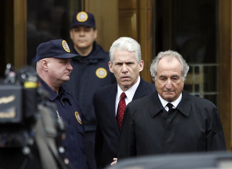 Bernard Madoff, right, exits the Manhattan federal courthouse in New York in this March 10, 2009, file photo. Madoff says through his efforts, victims could be repaid all their original principal. He also claims he has information that